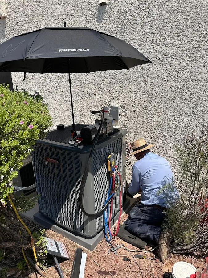 HVAC technician performing outdoor AC maintenance in Arizona City