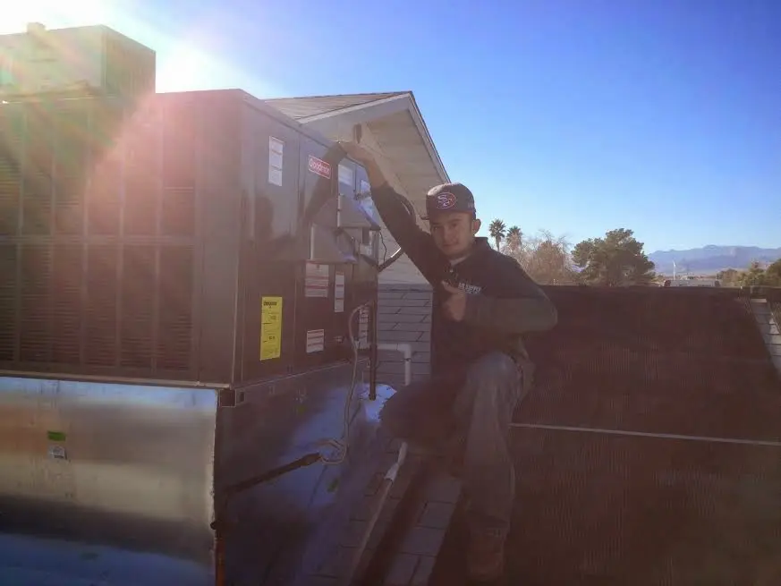 HVAC technician performing HVAC Inspection on a rooftop unit in Arizona City